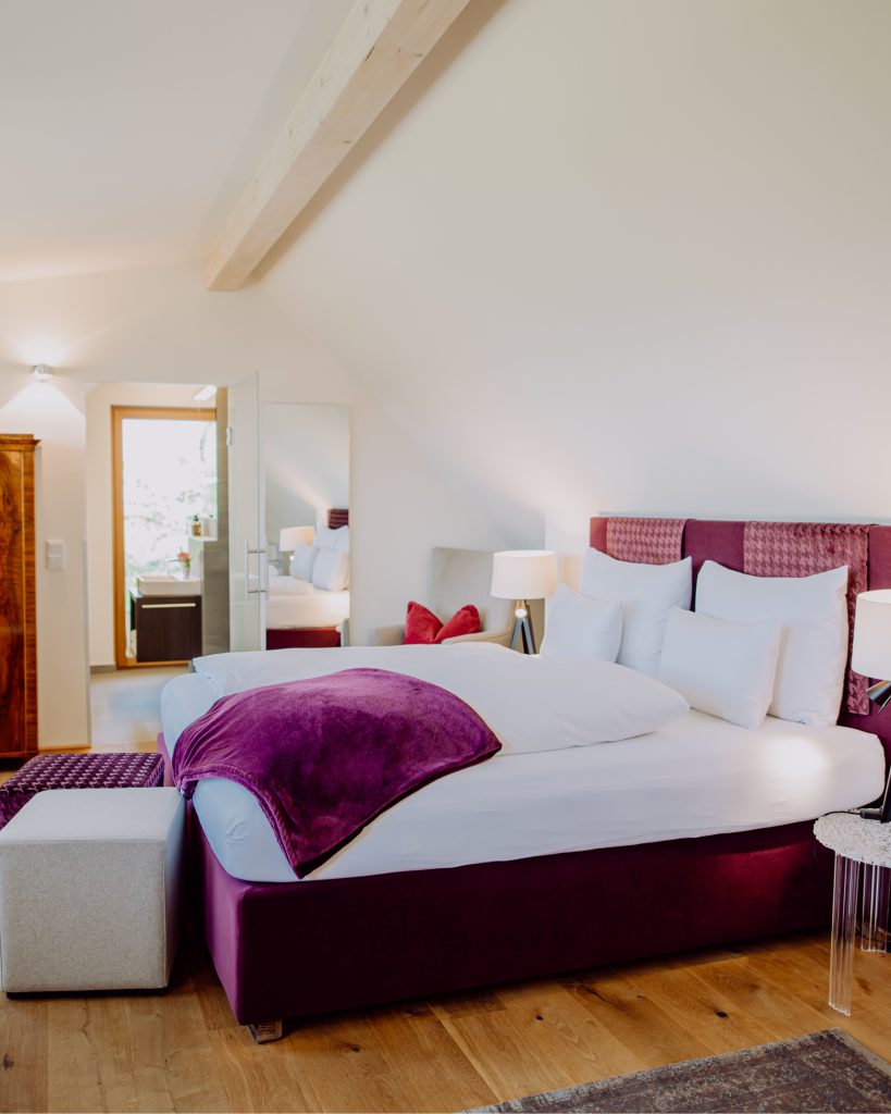 Schlafzimmer mit Bett und sicht aufs Badezimmer vom Winkel Art Hotel